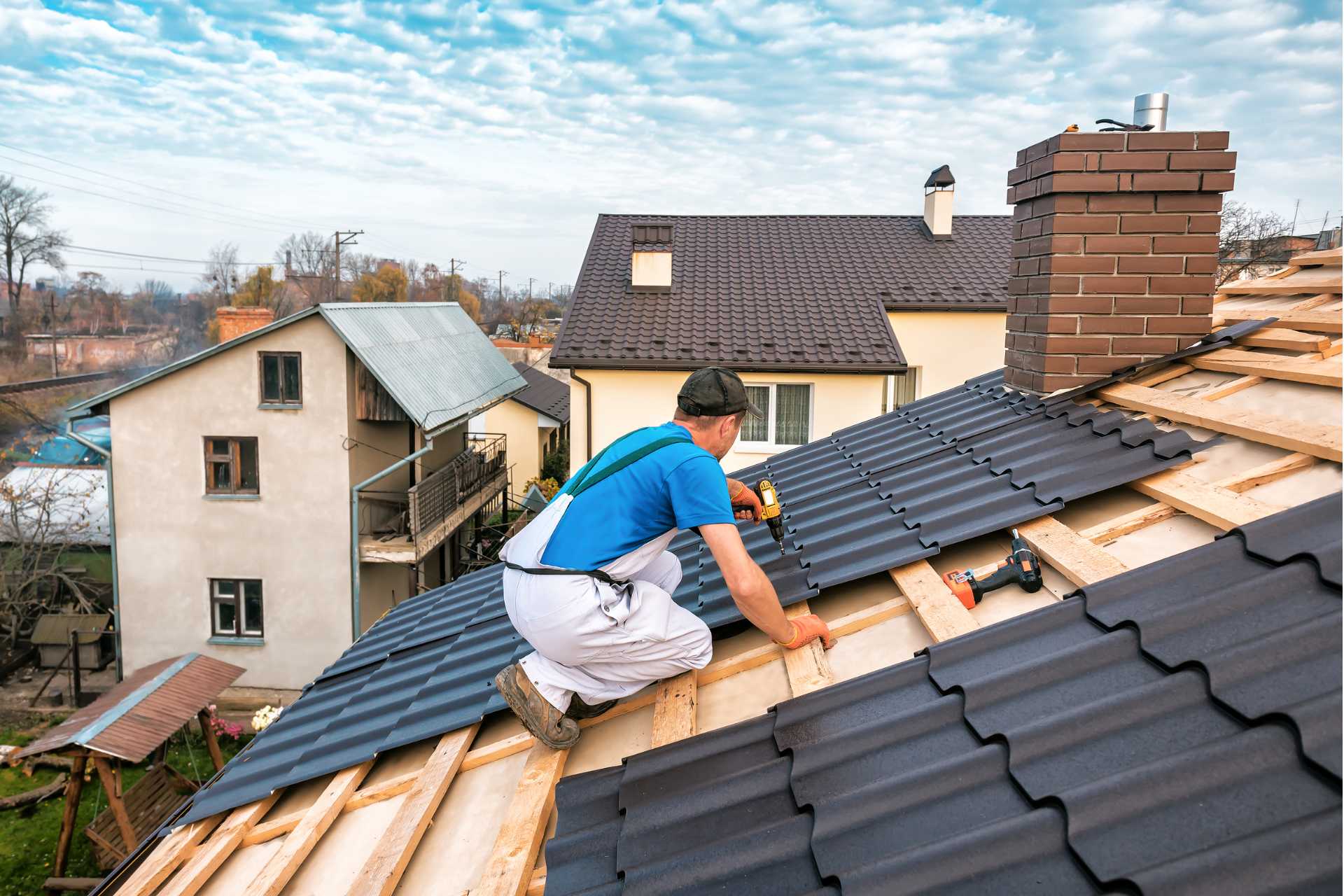 professional roofer working on roof painting 